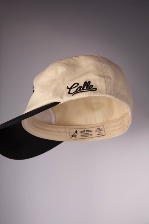 Beige cap with 'Calle' logo on a gray background