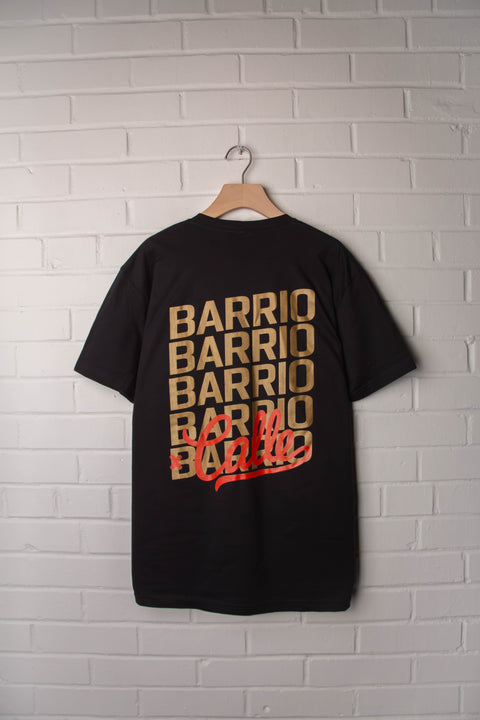 Black t-shirt with 'BARRIO' printed multiple times on a white brick wall background
